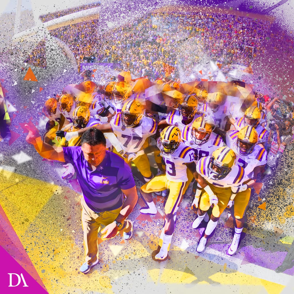 LSU players charging onto the field behind their coach through purple and gold confetti